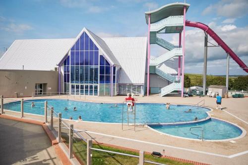 a large swimming pool with a slide in front of a building at Combe Haven in Hastings