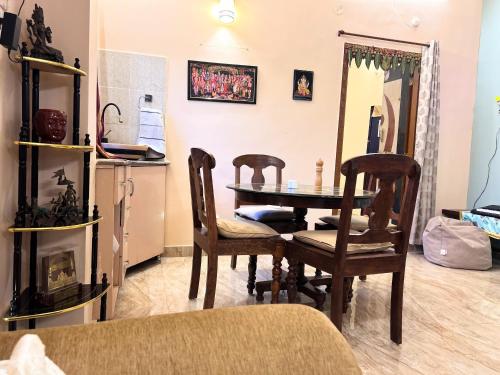 a dining room with a table and chairs and a refrigerator at Green Serene Estate & home-stay in Puttaparthi
