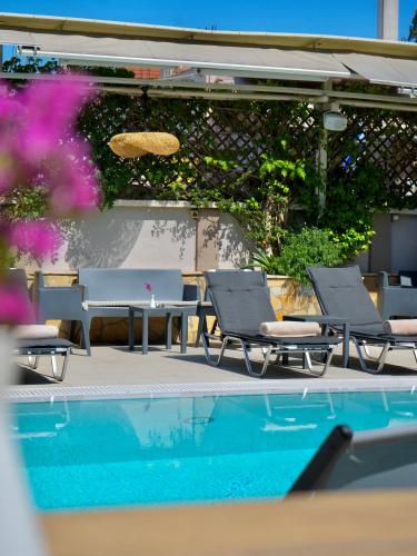 a group of chairs and a swimming pool at Telesilla Hotel in Kontokali