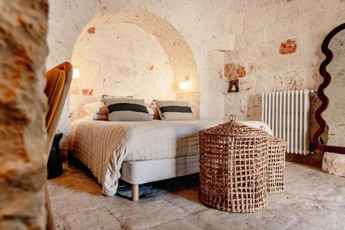 a bedroom with a bed and a wicker table at Trullo Zaira in Alberobello