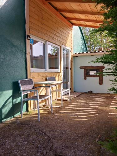 d'une terrasse avec une table, des chaises et un banc. dans l'établissement Harmonie Spirit 9, à Rauret