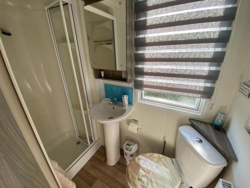 a small bathroom with a toilet and a sink at Island Escape Sandown in Sandown