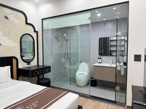 a bathroom with a shower and a toilet and a sink at Riverside Hotel Hoa Lư Old Town in Ninh Binh