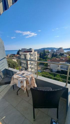 a balcony with a table and chairs and the ocean at Blue wave apartman in Becici