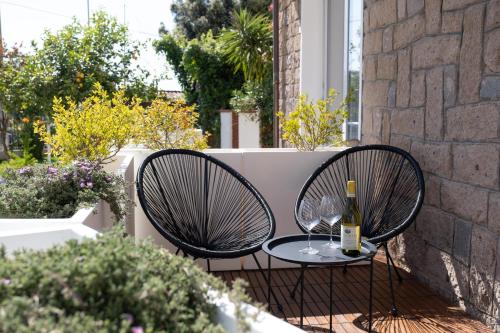 two chairs and a table with a bottle of wine at Nautika Suites in Alghero