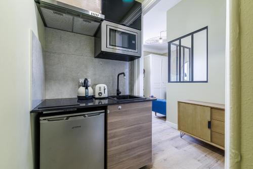 une cuisine avec un évier et un lave-vaisselle dans l'établissement Lueur Provençale, à Villeneuve-Loubet