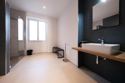 a bathroom with a white sink and black walls at Nautika Suites in Alghero