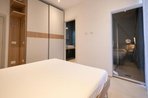 a bedroom with a white bed and a bathroom at Nautika Suites in Alghero