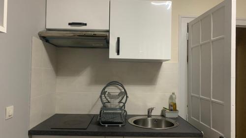 un comptoir de cuisine avec un évier et un évier dans l'établissement Appartement cosy wifi à deux pas des Thermes, à La Bourboule