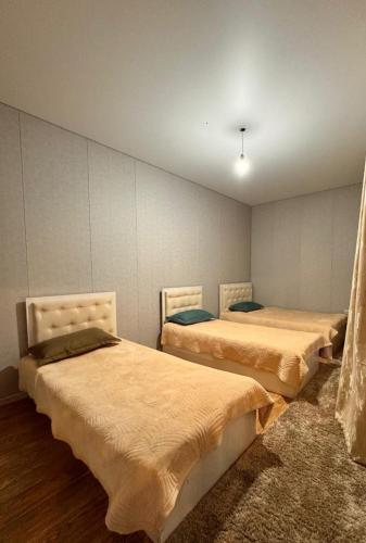 a bedroom with two beds in a room at Гостевой дом KOLSAY ROOM in Saty
