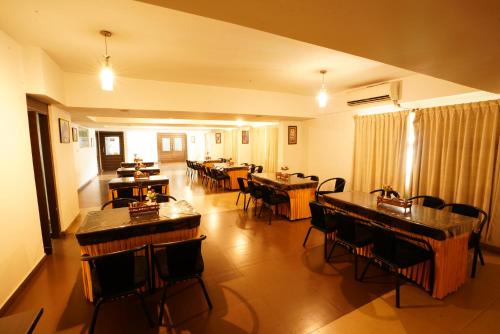 a dining room with tables and chairs in a room at Hotel Grand Bee , Yeshwanthpur Junction in Bengaluru