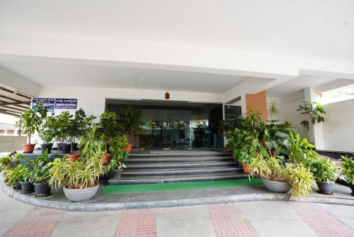 a building with a bunch of potted plants and stairs at Hotel Grand Bee , Yeshwanthpur Junction in Bengaluru