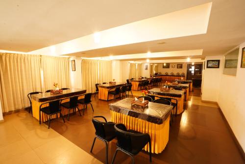 a restaurant with tables and chairs in a room at Hotel Grand Bee , Yeshwanthpur Junction in Bengaluru