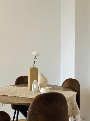 une table en bois avec des chaises et un vase. dans l'établissement Lovely Appartement-2rooms-6p sunshine-quiet-subway, à Paris