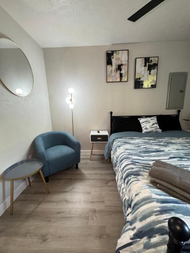Un dormitorio con una cama y una silla azul. en 4 STATE FAIR l DT Dallas l FIFA READY l Staycation 1Bd1Ba, en Dallas