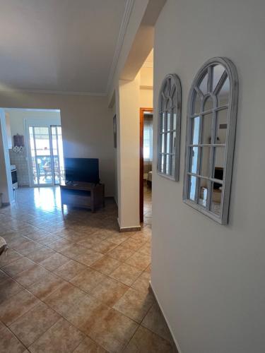 an empty living room with two mirrors on a wall at Seaside Apartment in Vergia in Vergia