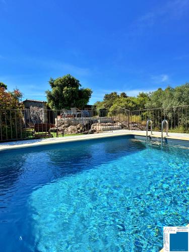 une grande piscine avec de l'eau bleue dans l'établissement A Sérénità - Bergerie - Piscine Privée, à Porto-Vecchio