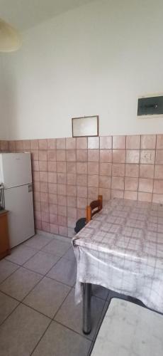 a room with a bed and a tiled wall at Windy Place in Fourfourás