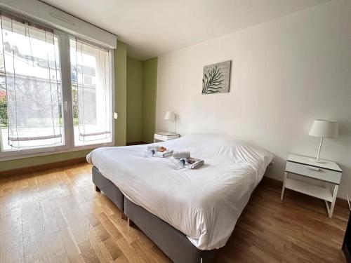 une chambre avec un grand lit blanc et deux fenêtres dans l'établissement Venise 6 couchages avec terrasse hyper centre, à Reims