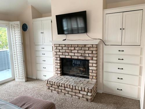 sala de estar con chimenea y TV en la parte superior en #Marbella Lane - 3BR Coastal Charm in Seal Beach, en Seal Beach