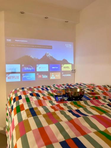 un écran de projection avec un lit avec un bol dessus dans l'établissement T2 RÉNOVÉ avec TERRASSE en HYPER CENTRE de Dijon, à Dijon