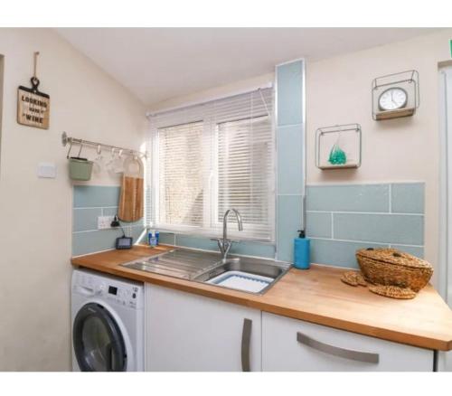 a kitchen with a sink and a washing machine at Willow Cottage Haverigg Millom in Haverigg