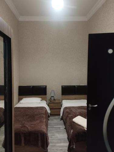 a hotel room with two beds and a light on the wall at Apartament ANASTASIA in Tbilisi City