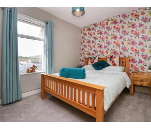 a bedroom with a bed with a flowery wallpaper at Willow Cottage Haverigg Millom in Haverigg