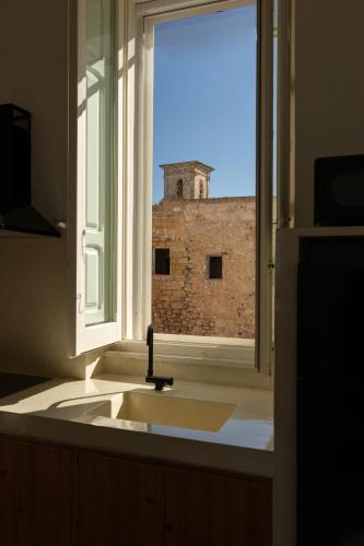 a kitchen sink with a window with a brick building at Fronte Mare Casa Daspa in Gallipoli