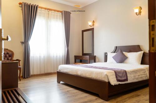 a bedroom with a bed and a large window at Nice Dream Villas in Da Lat