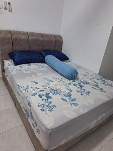a bed with blue pillows on top of it at TheRapy House in Malacca