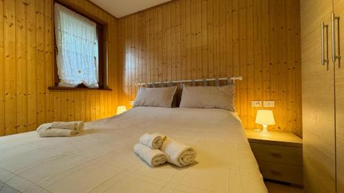 a bedroom with a large bed with towels on it at Il Giardino sull'Antelao in Masariè