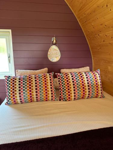 a bedroom with a bed with a purple wall at Southwell Retreat Glamping Pods in Southwell