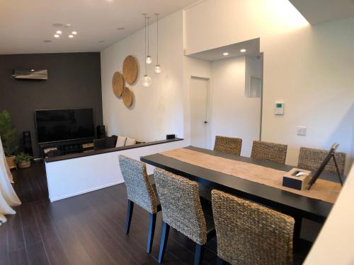 a living room with a dining table and chairs at 美ら海水族館まで車で3分の好立地ジャグジー付きの1棟貸Suppai Resort Okinawa in Motobu