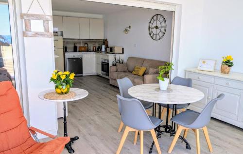 - une cuisine et un salon avec deux tables et des chaises dans l'établissement T3 refait à neuf vue mer, piscine, clim, garage, wifi, à Sète