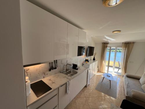 a kitchen with white cabinets and a blue stool at Medulin - Romeo - Wohnung direkt am Meer in Medulin