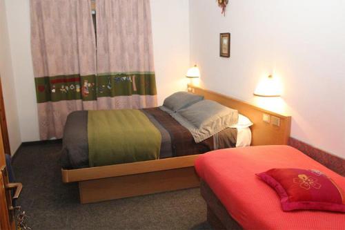 a room with two beds in a hotel room at Hotel Genziana in Passo Stelvio