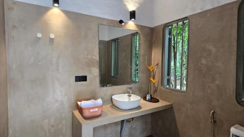 a bathroom with a sink and a mirror at Clove Estate - A Quiet Living in Walagedera
