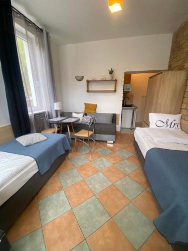 a room with two beds and a table and a couch at Dom na Fali Darlowko in Darlowko