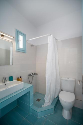 a bathroom with a white toilet and a sink at Eleios Hotel Serifos in Livadi