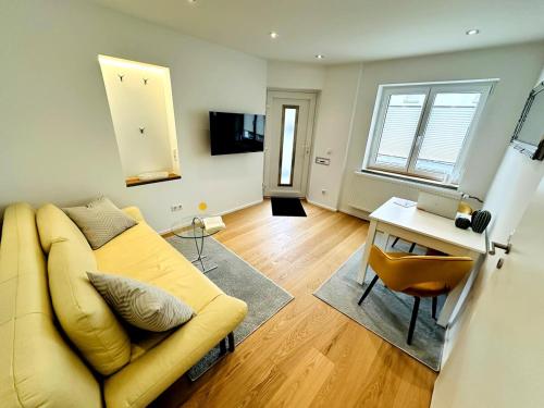 a living room with a yellow couch and a table at Apartment um Herzen von Echterdingen in Leinfelden-Echterdingen