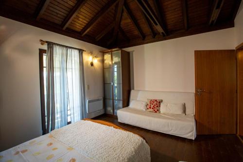 a bedroom with two beds and a window at Eco Stone Villa with Private Pool and Jacuzzi in Kalandra