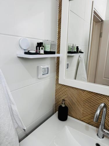 a bathroom with a sink and a mirror at המקום של רוני ותמיר - יחידת אירוח גלילית in Yuval
