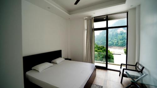 a bedroom with a bed and a large window at Phool Chatti Yoga Ashram 7 day Yoga Retreat in Shivpuri