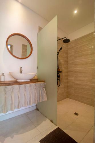 a bathroom with a sink and a mirror at Simple & Magical Villas PRAYA in Seminyak