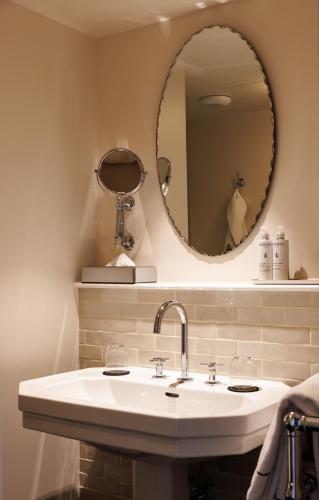 a bathroom with a sink and a mirror at Domaine de Locguénolé & Spa - Relais & Chateaux in Kervignac