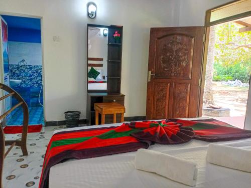 a bedroom with a bed with a colorful blanket on it at Sigiriya Moon Mirage Villa in Sigiriya