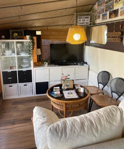 a living room with a couch and a table at Campingwohnung am Silbersee in Freiburg in Freiburg im Breisgau