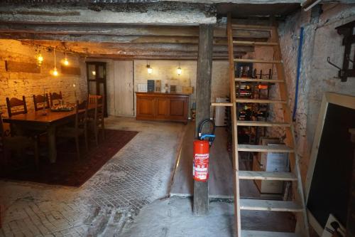 a room with a ladder and a dining room with a table at Chambre d'hôtes Juste-Confortable in Fleurey-lès-Lavoncourt