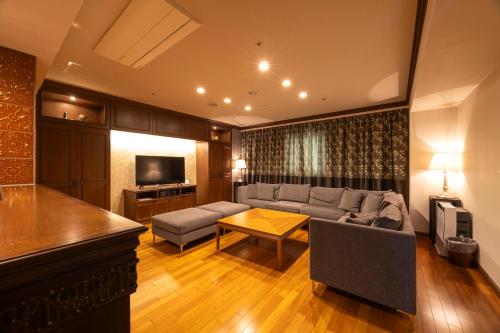 a living room with a couch and a table at Kushiro Century Castle Hotel in Kushiro